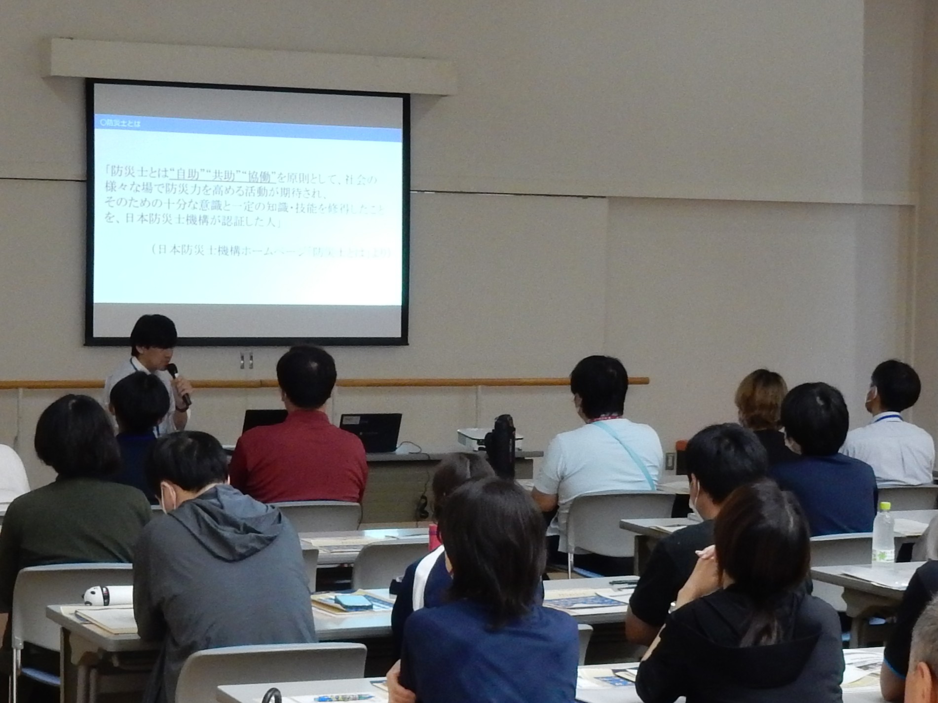 小松島市の防災に関する取組について説明しています。
（説明内容：福祉施設との避難訓練の共同実施について。防災士資格取得に係る市独自の支援制度について。）