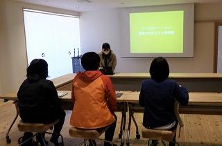 研修室で概要説明を受ける参加者