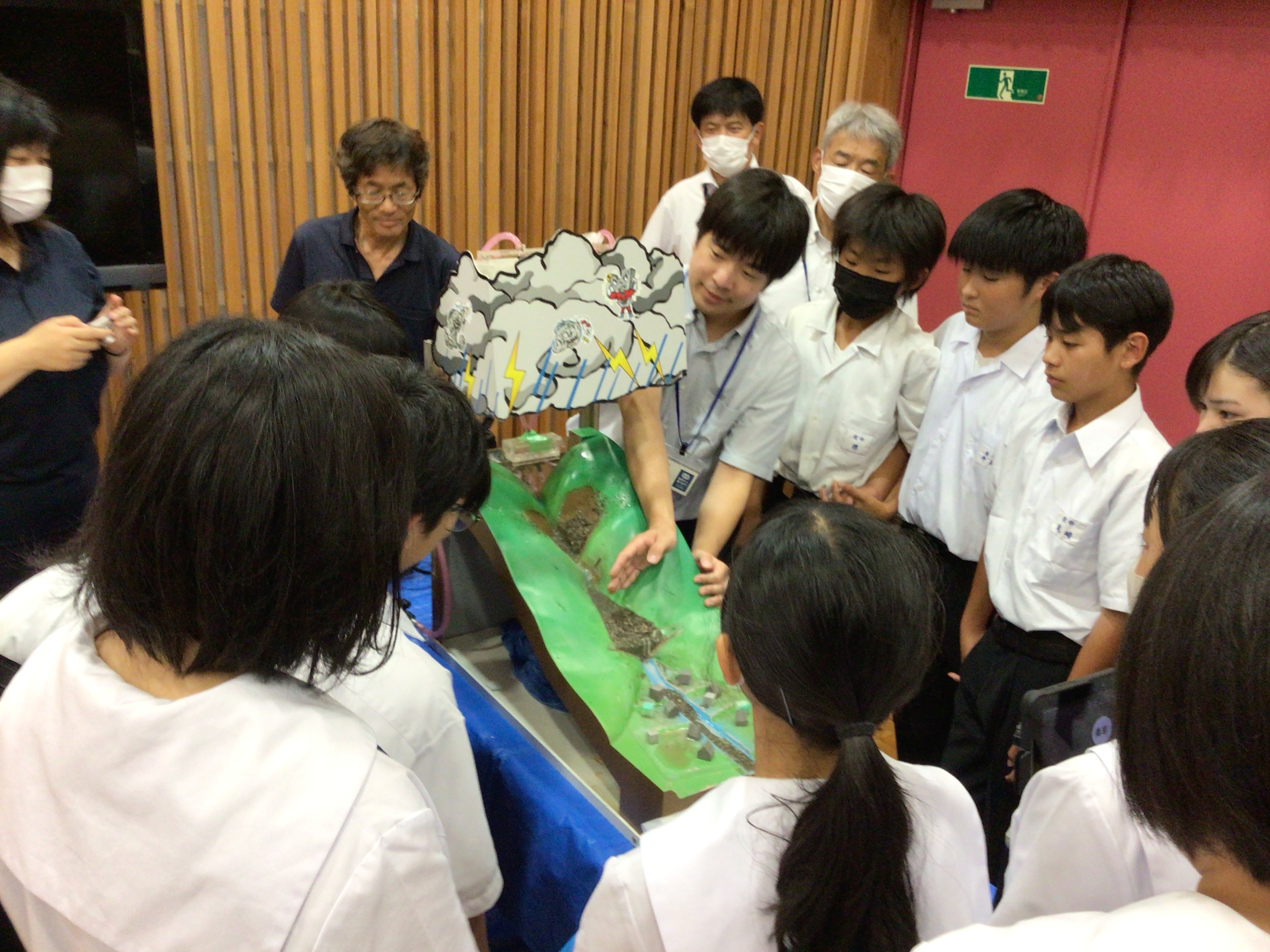 土石流実験装置で砂防堰堤の役割について学習している様子